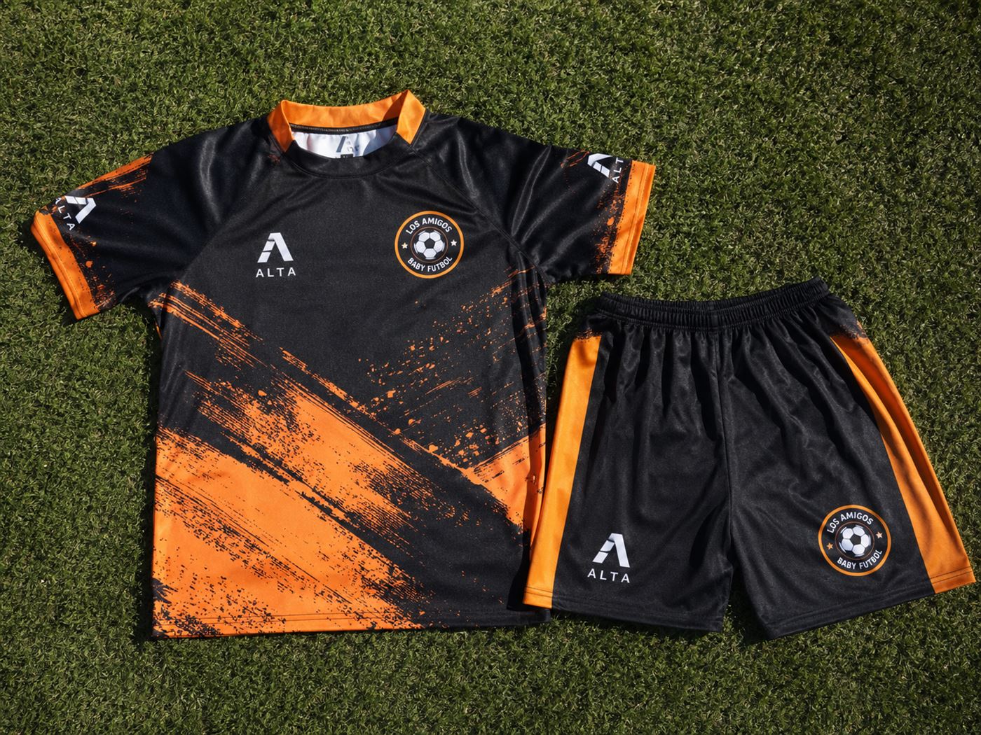 Camiseta y short de fútbol infantil negro y naranja con escudo